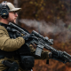 A man holding his rifle sling at a ready position while shooting at the range.